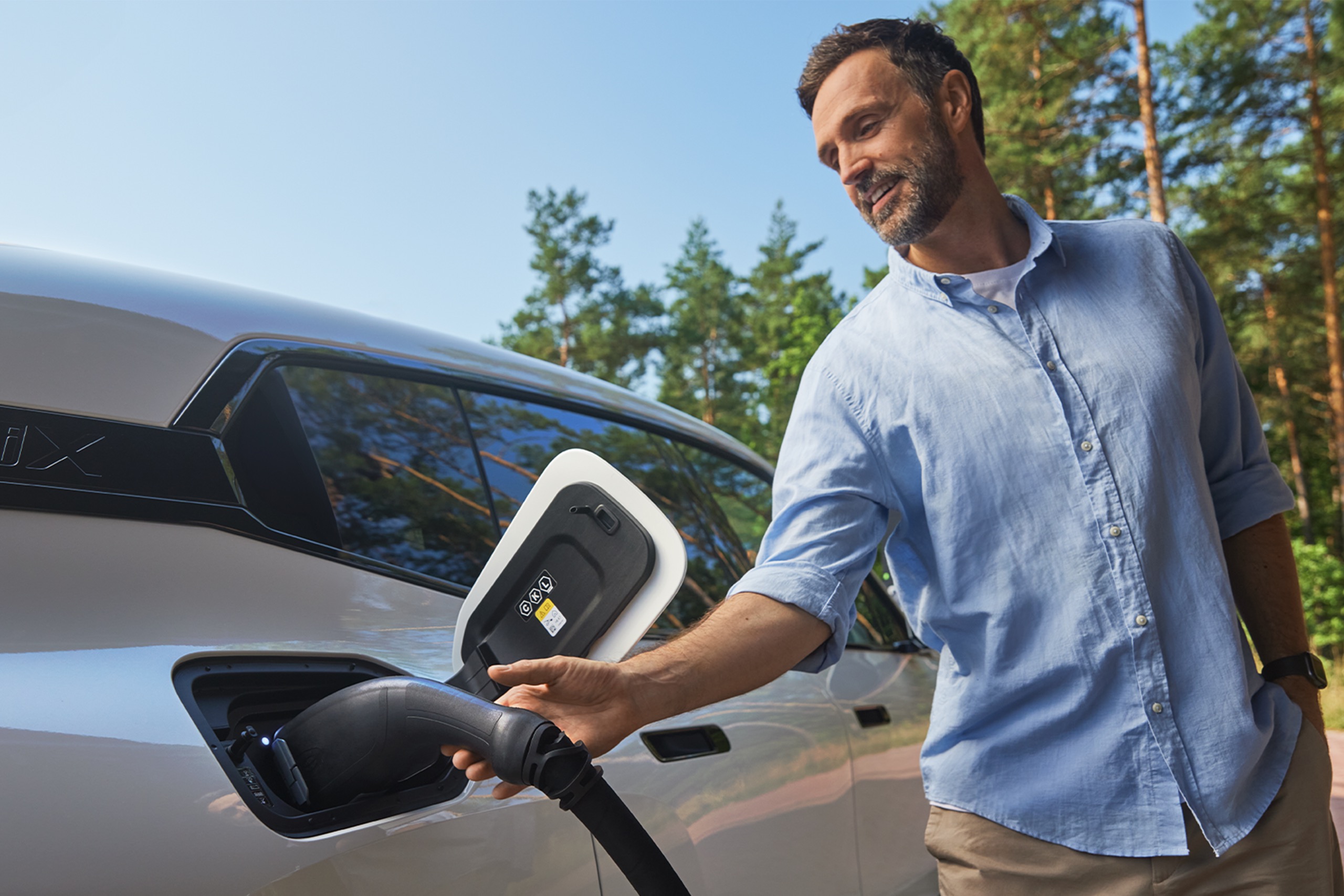 Mann lädt Elektrofahrzeug